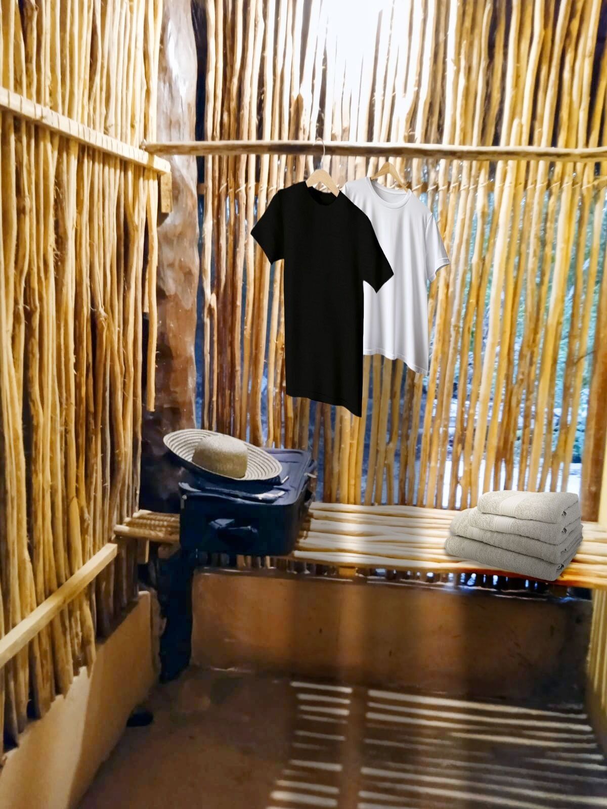 A room with a bamboo wall, a bed with a white towel, and a suitcase with a hat on it.