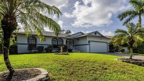 A two-story house with a well-maintained lawn, a fountain, and a garage. - Lovely three-bedroom two-bathroom with pool and spa, and a short distance to Tigertail (Marco Island)