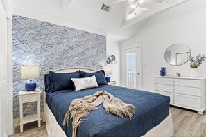 Un dormitorio con una cama grande, una mesita de noche, un aparador y un espejo.