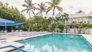 A swimming pool with lounge chairs and palm trees. - Shipyard in Key West, FL (Key West)