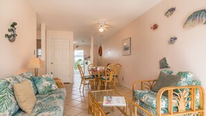 A room with a sofa, a coffee table, and a dining table with chairs. - Shipyard in Key West, FL (Key West)