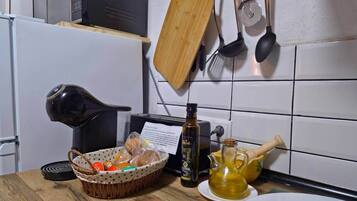 A kitchen with a microwave, toaster, wooden cutting board, and various utensils.
