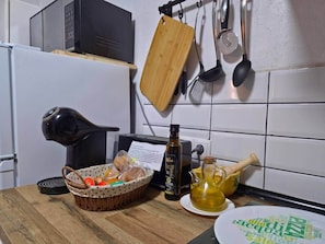 A kitchen with a microwave, toaster, wooden cutting board, and various utensils. - Tinguaton 2 (Aldeanueva de Barbarroya)