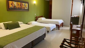 A hotel room with two beds, a green wall, a painting, a television, and a desk with a chair. - Hotel San Francisco (Barranquilla)