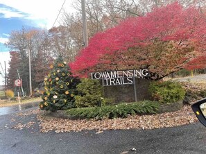 Um letreiro para Towamensing Trails com um cenário de folhagem outonal e uma árvore de Natal.