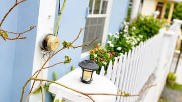 A house with a white picket fence, a blue exterior wall, and a small window.