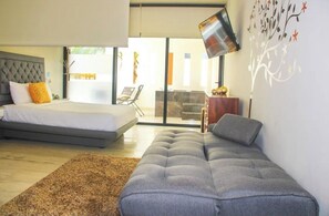 Relax in this stylish bedroom with a large bed, flat-screen TV, and comfortable sofa, plus access to an outdoor seating area.