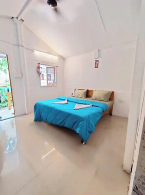 Un dormitorio con cama, ventana y puerta.