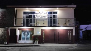 A two-story building with a sign reading "Hotel el Encanto."