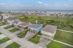 A residential area with houses, a road, and a beach in the background. - Smiles in Isla Del Sol | House in Galveston (Galveston)