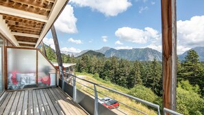 Ein Balkon mit Blick auf eine gebirgige Landschaft.
