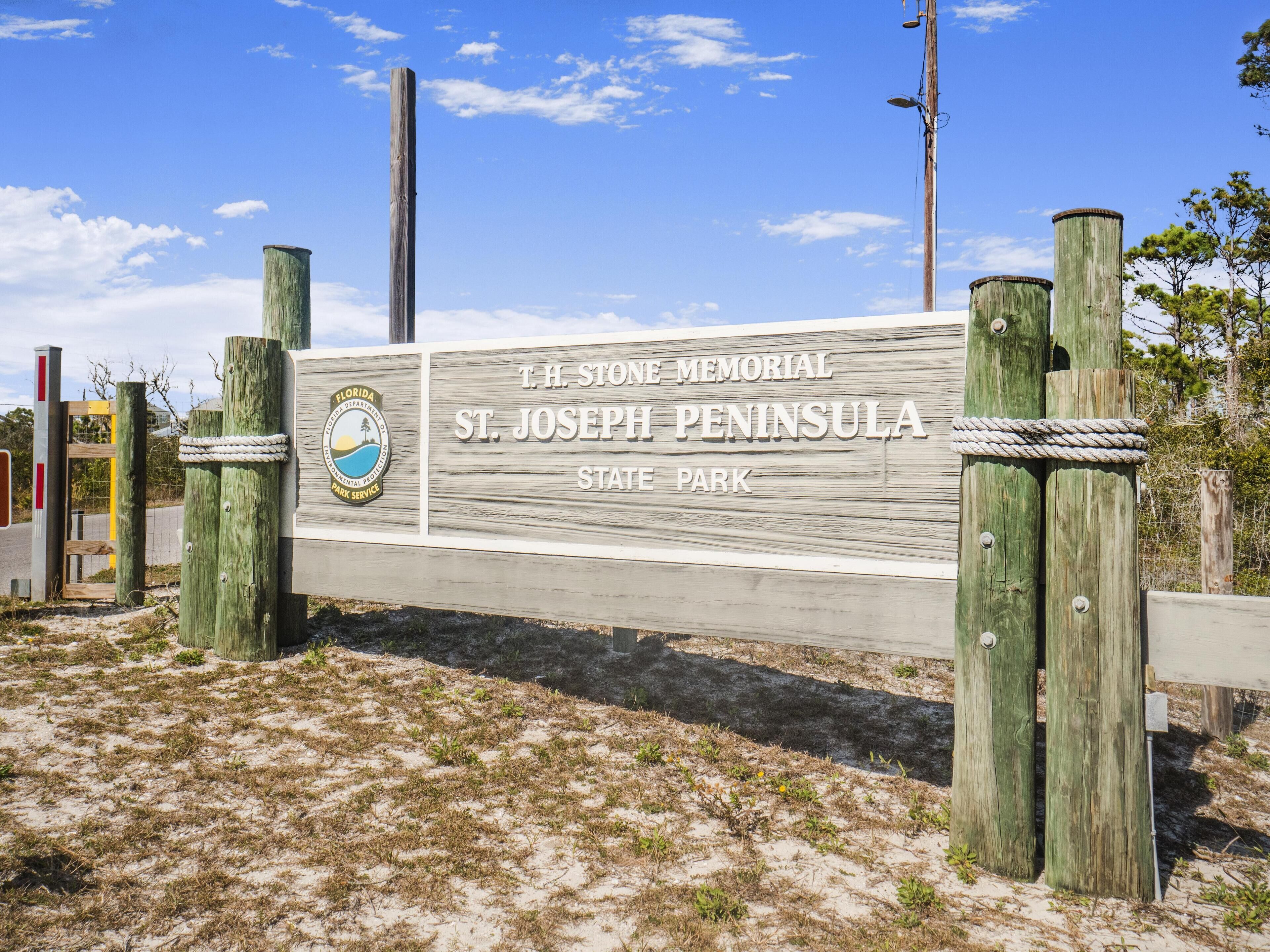 A wooden sign for T.H. Stone Memorial State Park with a Florida Department of Environmental Protection logo.