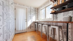 Una cocina con encimera de madera, taburetes de bar y una ventana con vistas.