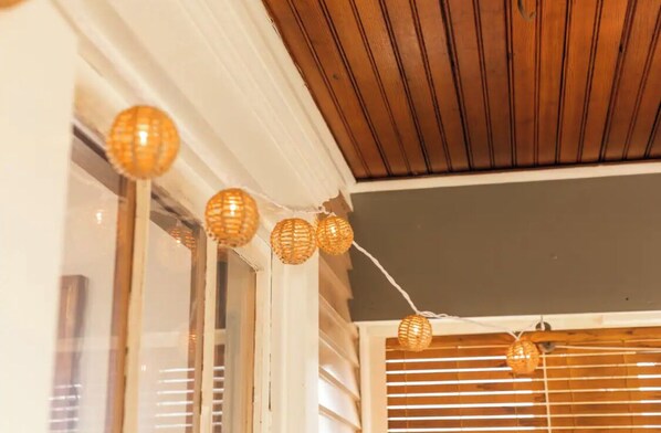 A ceiling with wooden paneling and a string of decorative spherical lights.