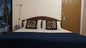 Cozy bedroom with a single bed, wooden headboard, and decorative pillows.