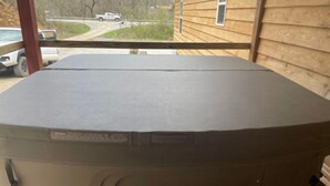 A large, beige outdoor heater with a control panel on the side, placed on a wooden deck. - 3BR, 2 Bath Cabin with full kitchen, living room, and hot tub. (Putney)