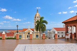 Vista costera con una iglesia, palmeras y un patio con tejas.