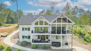 A two-story house with a large balcony, a covered patio, and a driveway.
