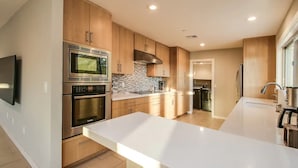 A modern kitchen with stainless steel appliances, wooden cabinets, and a large island. - Beautiful views with a heated pool and plenty of room for large families! (Fountain Hills)