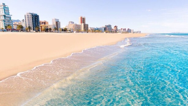 A beach with clear blue water and a city skyline in the background. - Villa GAN EDEN a gem in a privileged environment (Barx)