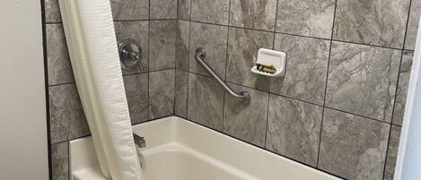 A bathroom with a bathtub, a shower, and a toilet.