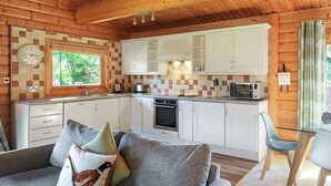 A cozy cabin-style kitchen with wooden walls, a built-in oven, and white cabinets. - 3 Bedroom, 5 star, award winning Lodge with luxurious hot tub (sleeps 6) (Winchester)