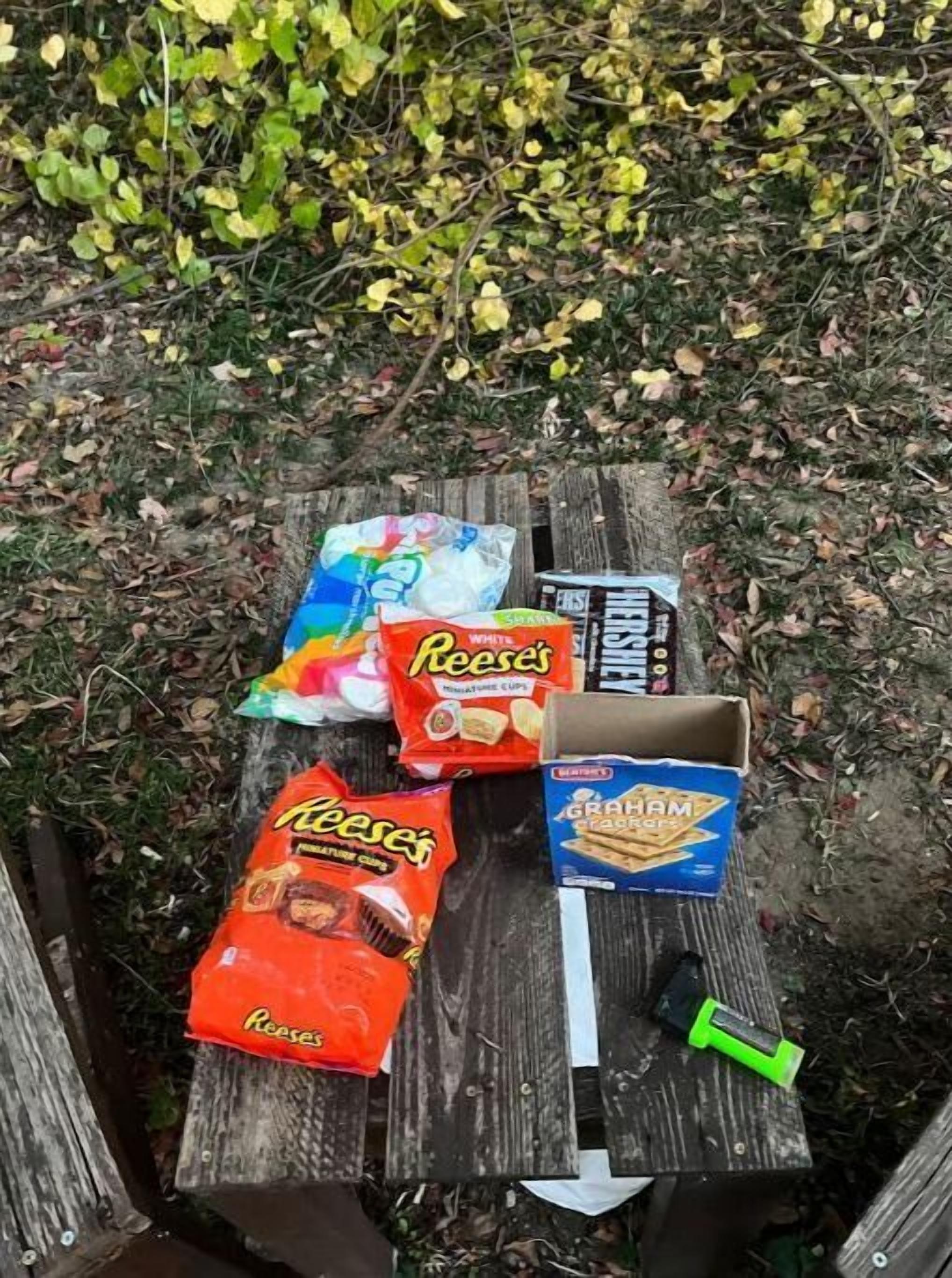 Une table de pique-nique avec des collations et une boîte de biscuits Graham.
