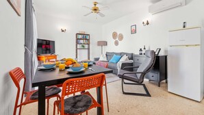 Een moderne woonkamer met een eethoek, een boekenkast en een televisie waarop 'NETFLIX' staat.