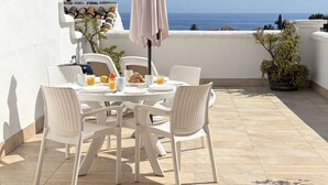 A round table with white chairs and a pink umbrella on a balcony overlooking the sea. - Tetuan 17 - El Oasis de Capistrano! (Nerja)