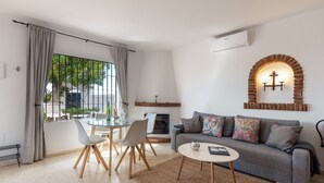 Een moderne woonkamer met een bank, salontafel en een eethoek.