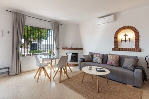 A modern living room with a sofa, coffee table, and dining area.