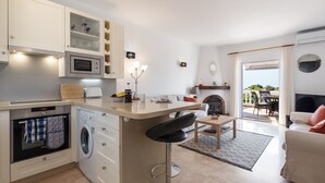 A modern kitchen with a central island, built-in appliances, and a dining area with a fireplace.