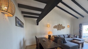 Un coin repas avec une table et des chaises en bois, un canapé et une lampe.