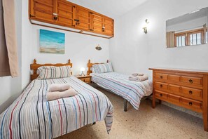 A bedroom with two beds, wooden cabinets, a painting, and a mirror. - Tetuan 11 - El Oasis de Capistrano! (Nerja)