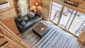 Un intérieur en bois avec un canapé en cuir, une table basse et un tapis à motifs.