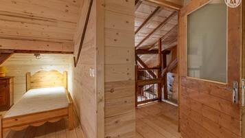 Une pièce en bois avec un lit, une porte et une fenêtre.