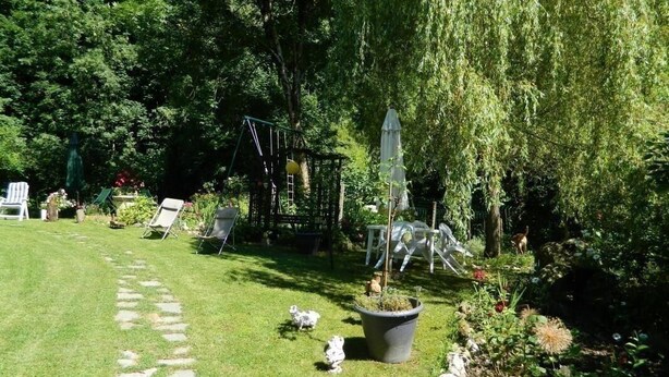 A well-maintained garden with a paved pathway, outdoor furniture, and a play structure. - L'ECLAIRCIE - THOIRY (THOIRY)