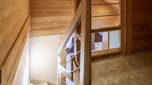 A wooden interior with a staircase leading to an upper level.