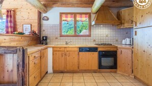 Una cocina de madera con ventana, un lavamanos, una estufa y un lavavajillas.