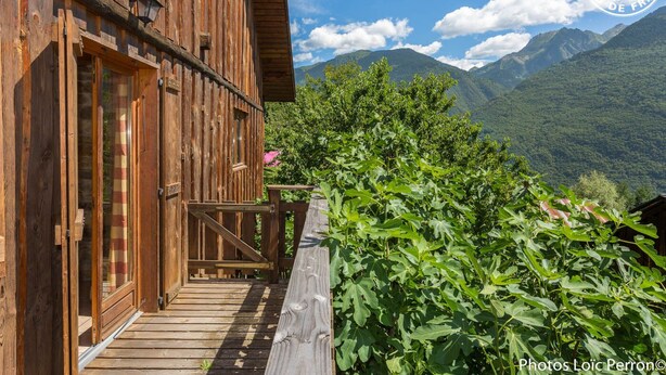 Un edificio de madera con balcón que da a un paisaje montañoso.