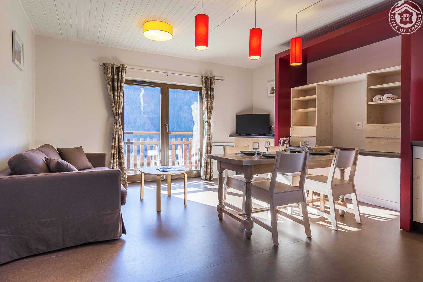 Un salon moderne comprenant un canapé, une table à manger et des chaises, un téléviseur et un balcon avec vue.