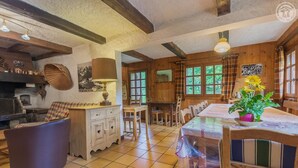 A rustic dining area with a long table, chairs, and a potted plant. - LE PLANAY - NOTRE DAME DE BELLECOMBE (NOTRE DAME DE BELLECOMBE)