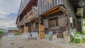 A rustic wooden building with a balcony, outdoor seating, and a grill area. - LE PLANAY - NOTRE DAME DE BELLECOMBE (NOTRE DAME DE BELLECOMBE)