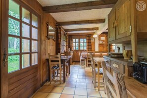 Un interior de madera con cocina, mesa y sillas.