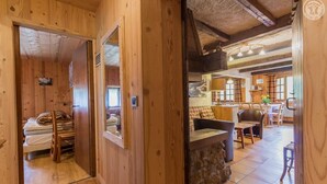 A wooden interior with a bed, a dining area, and a kitchen. - LE PLANAY - NOTRE DAME DE BELLECOMBE (NOTRE DAME DE BELLECOMBE)