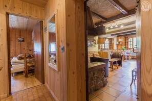 A wooden interior with a bed, a dining area, and a kitchen.