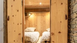 A wooden room with a bed, a bench, and a stone wall. - LE BIVOUAC - AUSSOIS (AUSSOIS)