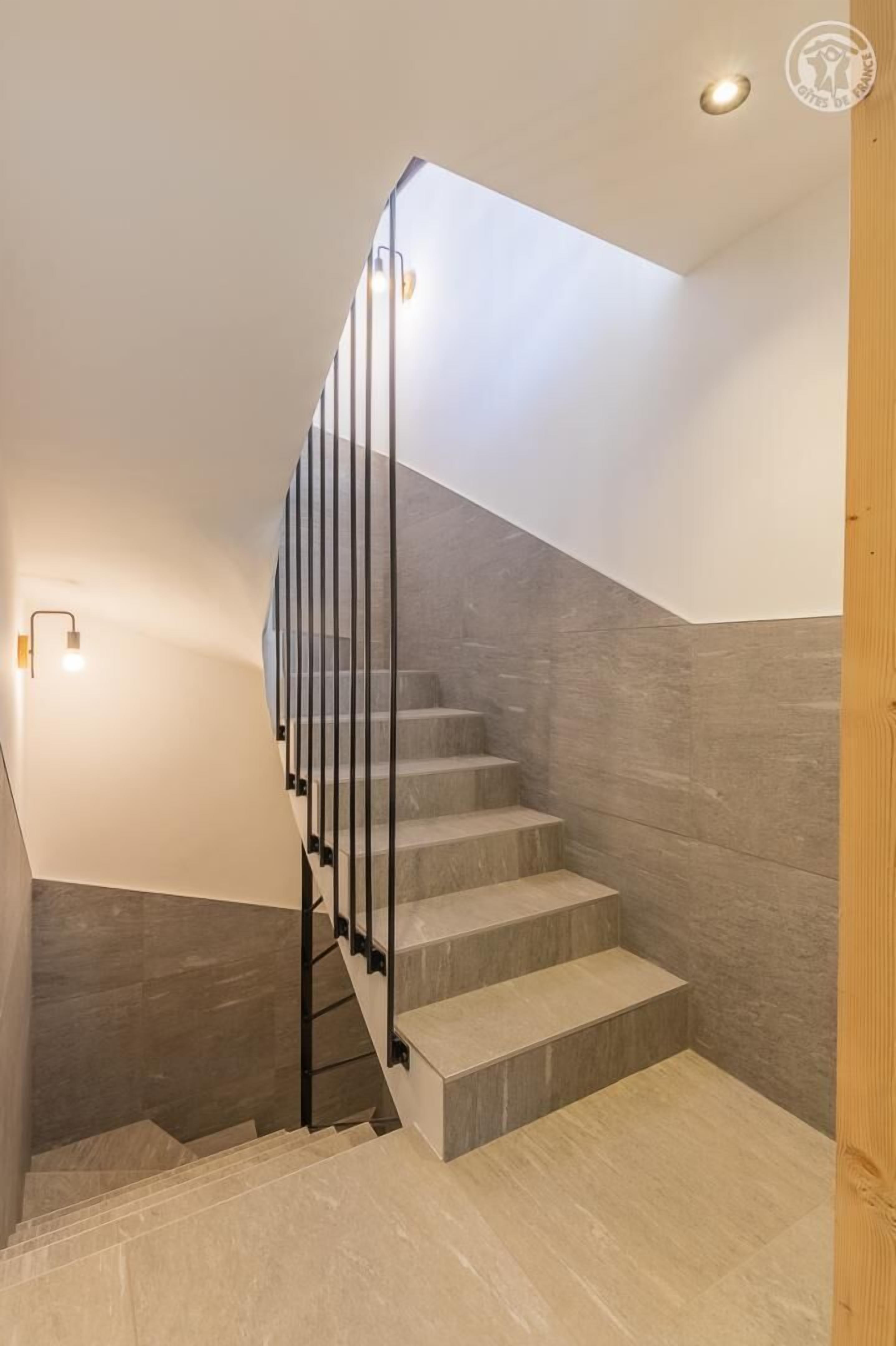 Eine moderne Treppe mit Glasgeländer und einem Oberlicht.