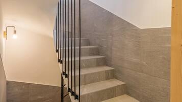 Eine moderne Treppe mit Glasgeländer und einem Oberlicht.