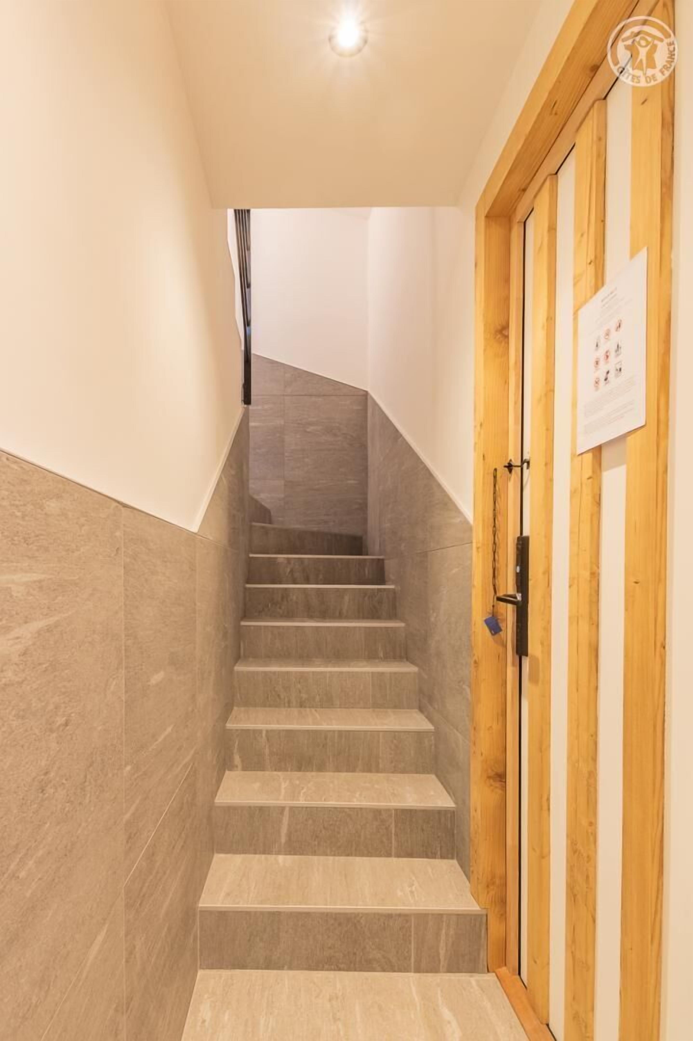 A staircase leading to a wooden door with a sign on it.